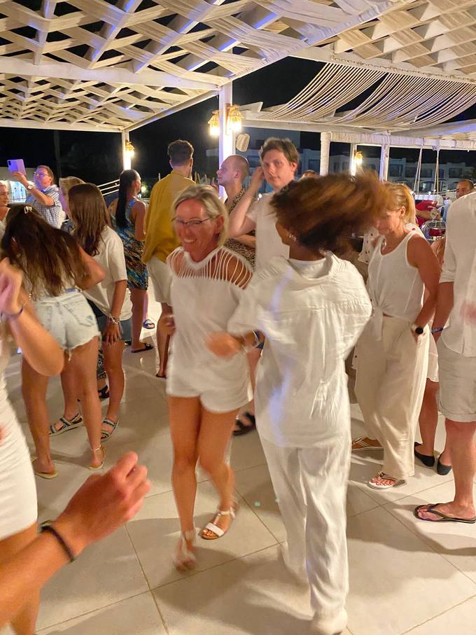 Guests dressed in white dancing at a night-time White Sensation party